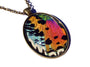 May include: A bronze oval pendant necklace with a colorful butterfly wing inside. The wing is iridescent and has shades of blue, green, orange, pink, and black. The pendant is on a chain.